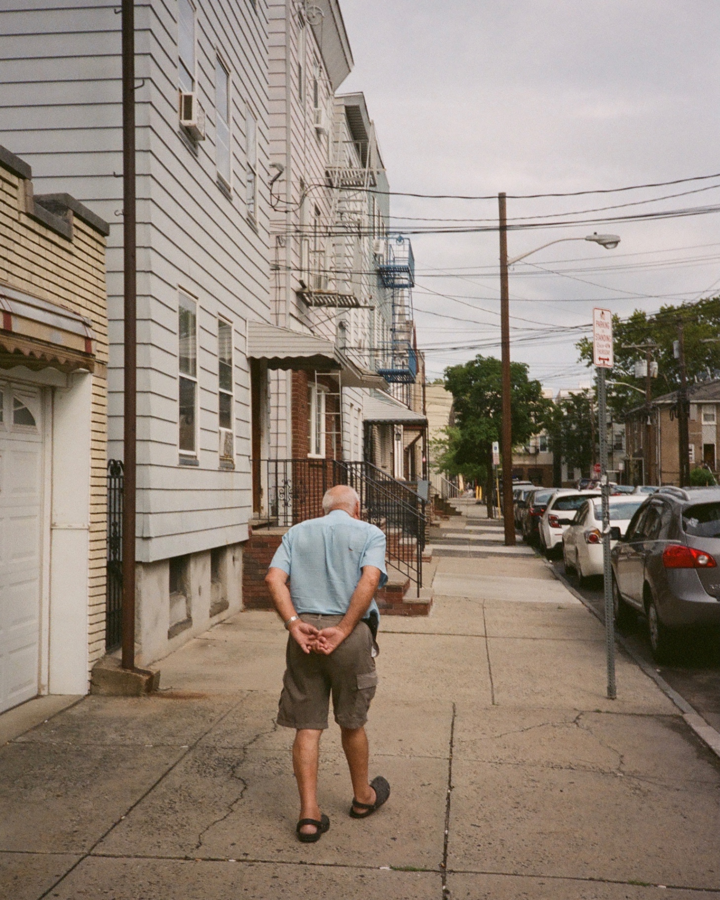 An elder walks an Ironbound side street lined with clapboard row houses and fire escapes.